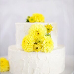 rustic white wedding cake with pretty yellow flowers