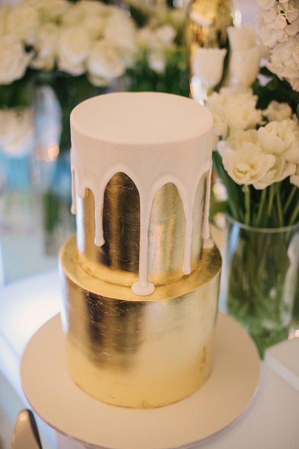 gold metallic wedding cake with dripping white icing